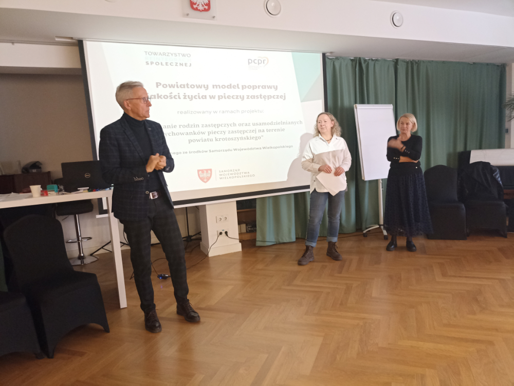Dwie prowadzące szkolenie oraz Dyrektor PCPR na tle ekranu ze slajdem
