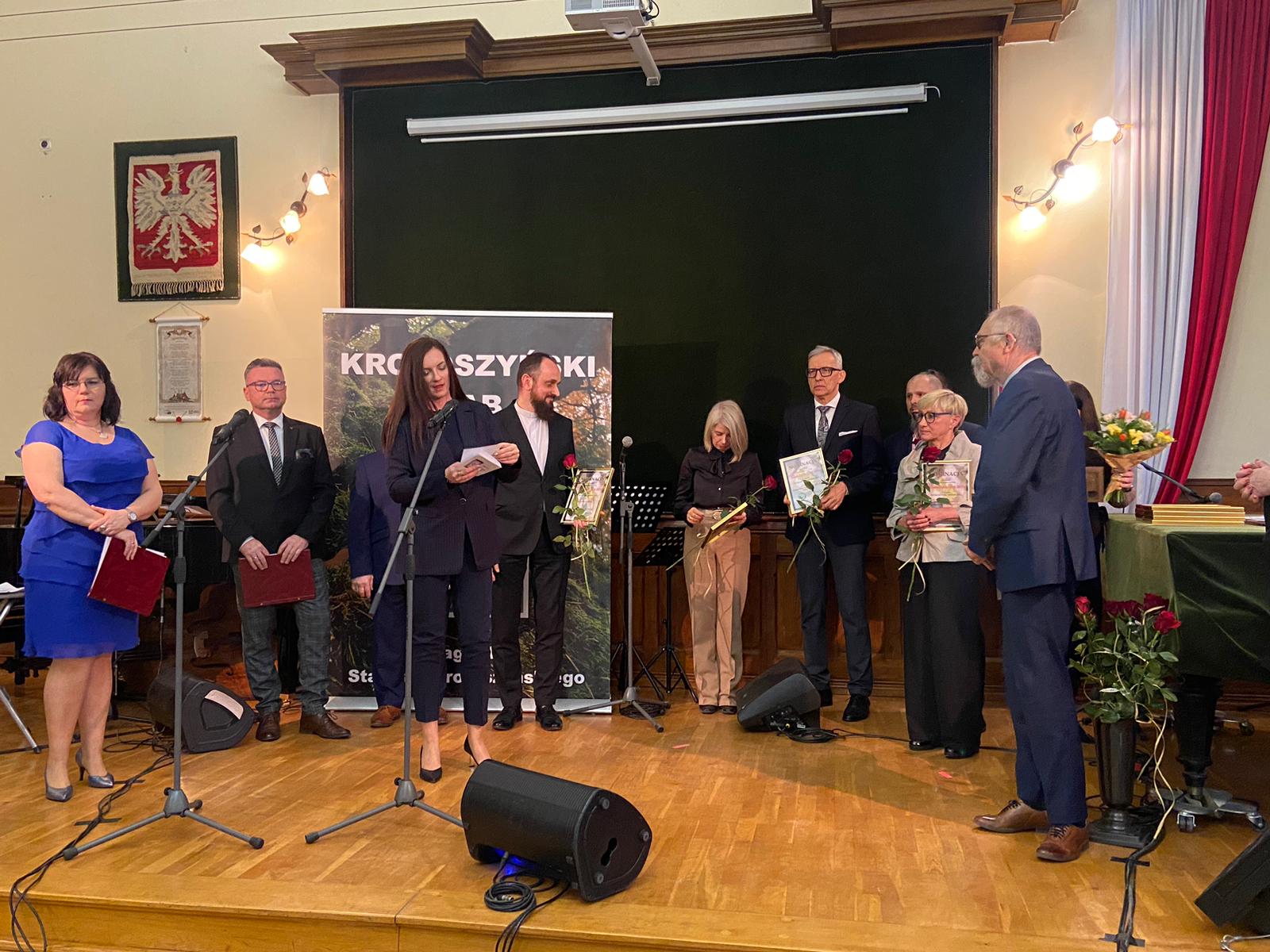 Kilka osób na scenie, nominowani do konkursu Starosty Krotoszyńskiego "Krotoszyński Dąb 2023